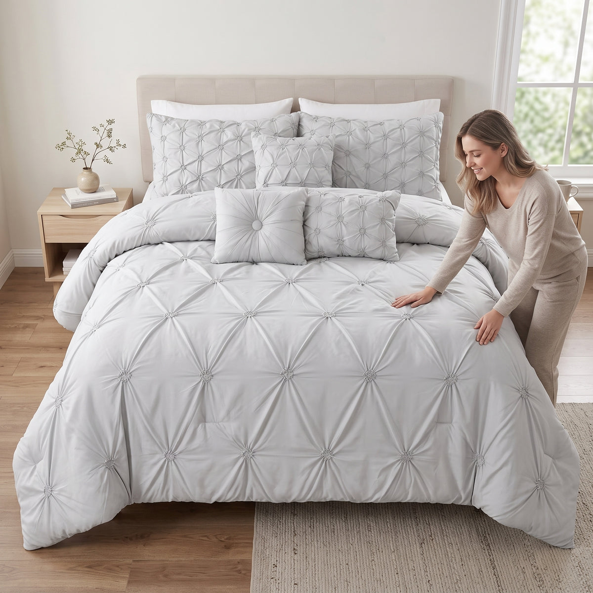 Ensemble de douillette King Chateau 7 pièces à plis pincés, gris, avec une femme qui lisse la douillette