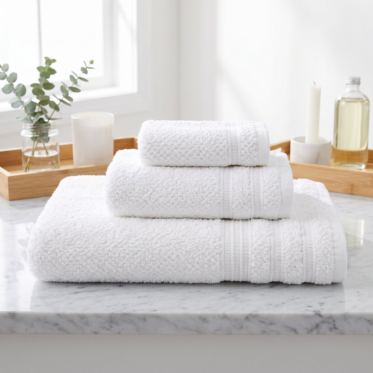 White textured cotton towels with woven border, in a bathroom setting